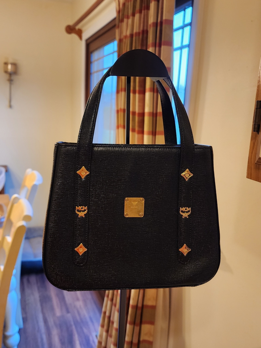 vintage MCM black studded leather top handle bag featuring gold-tone hardware. 